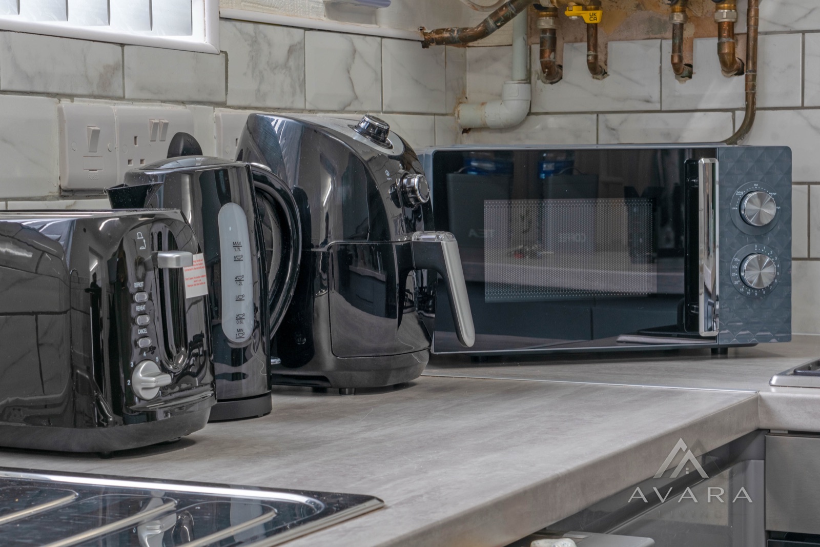 Kitchen appliances including air fryer and microwave at Avara Living